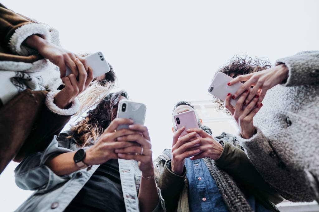 Pessoas usando celulares (KARRASTOCK/Getty Images)