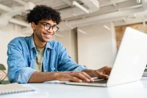 Jovem adulto negro usando o computador no trabalho