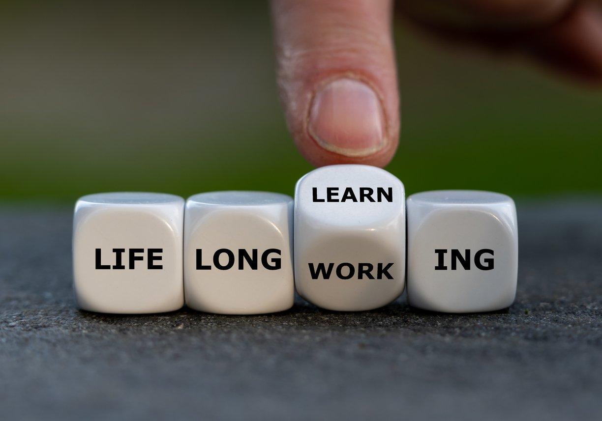 A mão vira dados e muda a expressão "trabalho ao longo da vida" para "aprendizagem ao longo da vida".