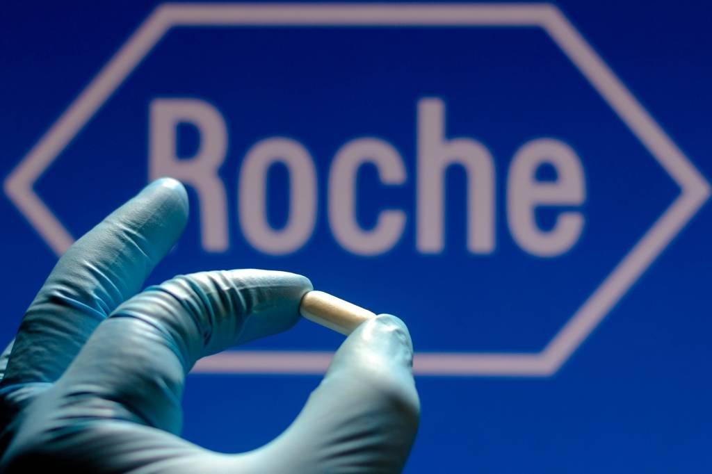 BRAZIL - 2021/11/26: In this photo illustration a F. HoffmannLa Roche AG logo is seen on a screen and a hand holding a pill. (Photo Illustration by Rafael Henrique/SOPA Images/LightRocket via Getty Images)