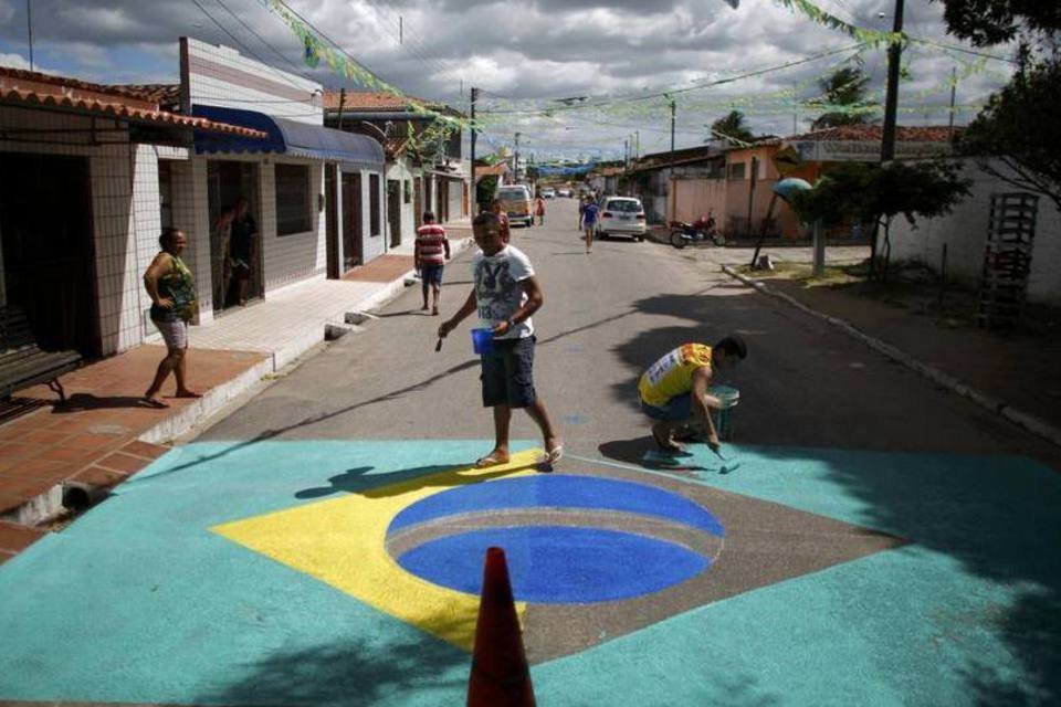 Moradores pintam uma bandeira do Brasil em uma rua próxima do aeroporto de Natal, no Rio Grande do Norte