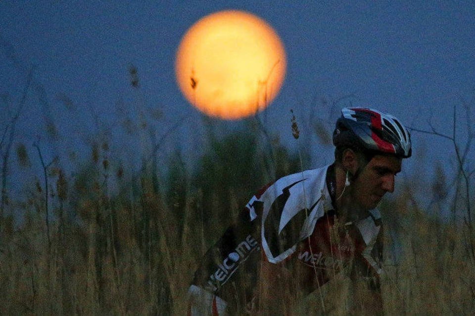 Ciclista pratica mountain bike sob a "lua azul" em Roma, Itália