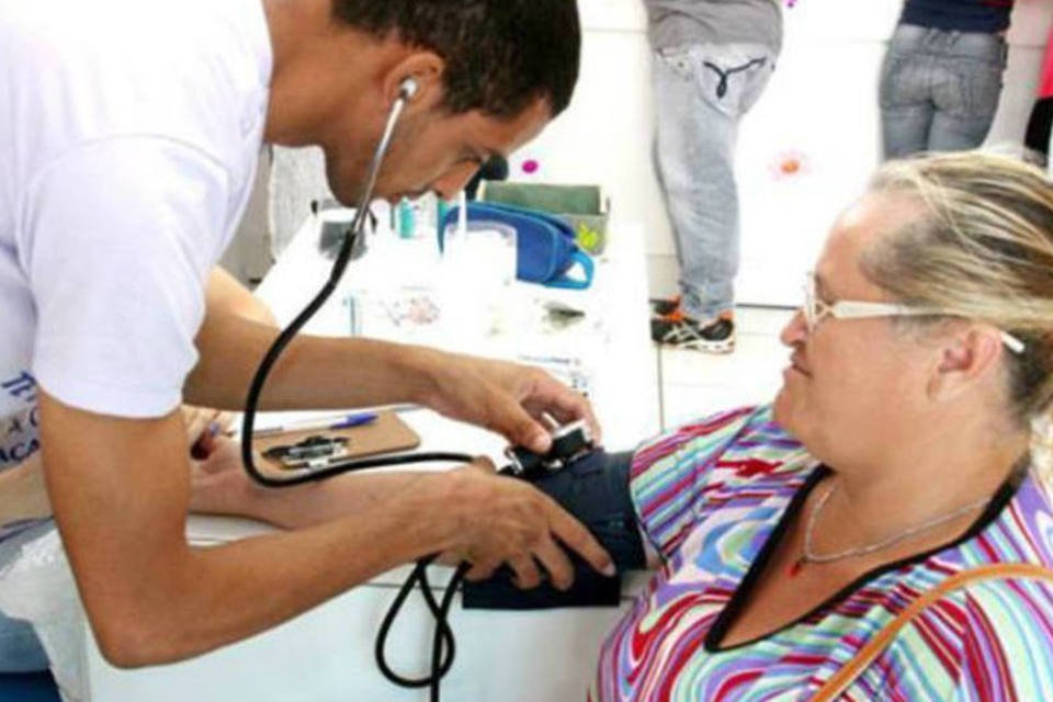 Enfermeiro mede pressão de moradora da cidade de Apucarana (PR)