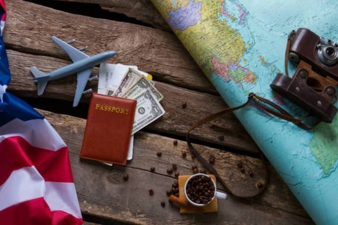Passaporte, aviões, dinheiro e a bandeira dos Estados Unidos (viagem, imigração)