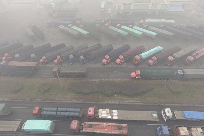 Caminhões são vistos encalhados perto de uma estrada durante um dia poluído em Shijiazhuang, província de Hebei, na China em 20 de dezembro de 2016.