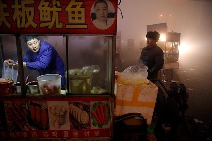Um vendedor de rua prepara comida para clientes em meio a poluição pesada na China em 20 de dezembro de 2016.