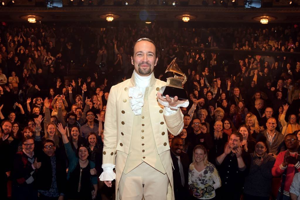 O compositor e ator Lin Manuel Miranda segurando seu Grammy no palco da peça Hamilton, dia 15/02/2016