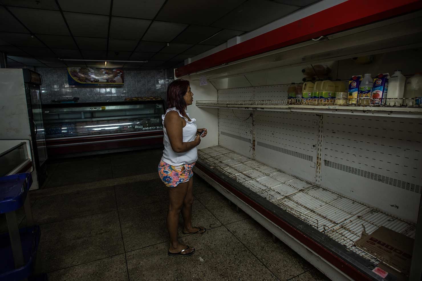 Maria Pinero em um supermercado vazio na cidade de La Vela; ela está deixando a Venezuela sem nada. "É isso ou morrer de fome". Foto de Meridith Kohut/ The New York Times