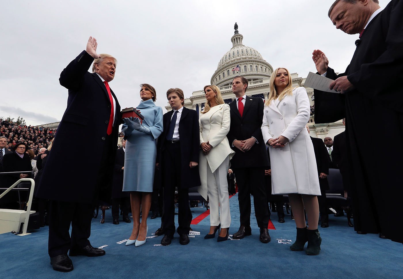 Donald Trump faz o juramento do cargo de presidente com sua esposa Melania segurando a Bíblia e ao lado de seus filhos Barron, Ivanka, Eric e Tiffany. Cerimônia foi conduzida pelo presidente do Supremo Tribunal John Roberts (Jim Bourg /Getty Images)