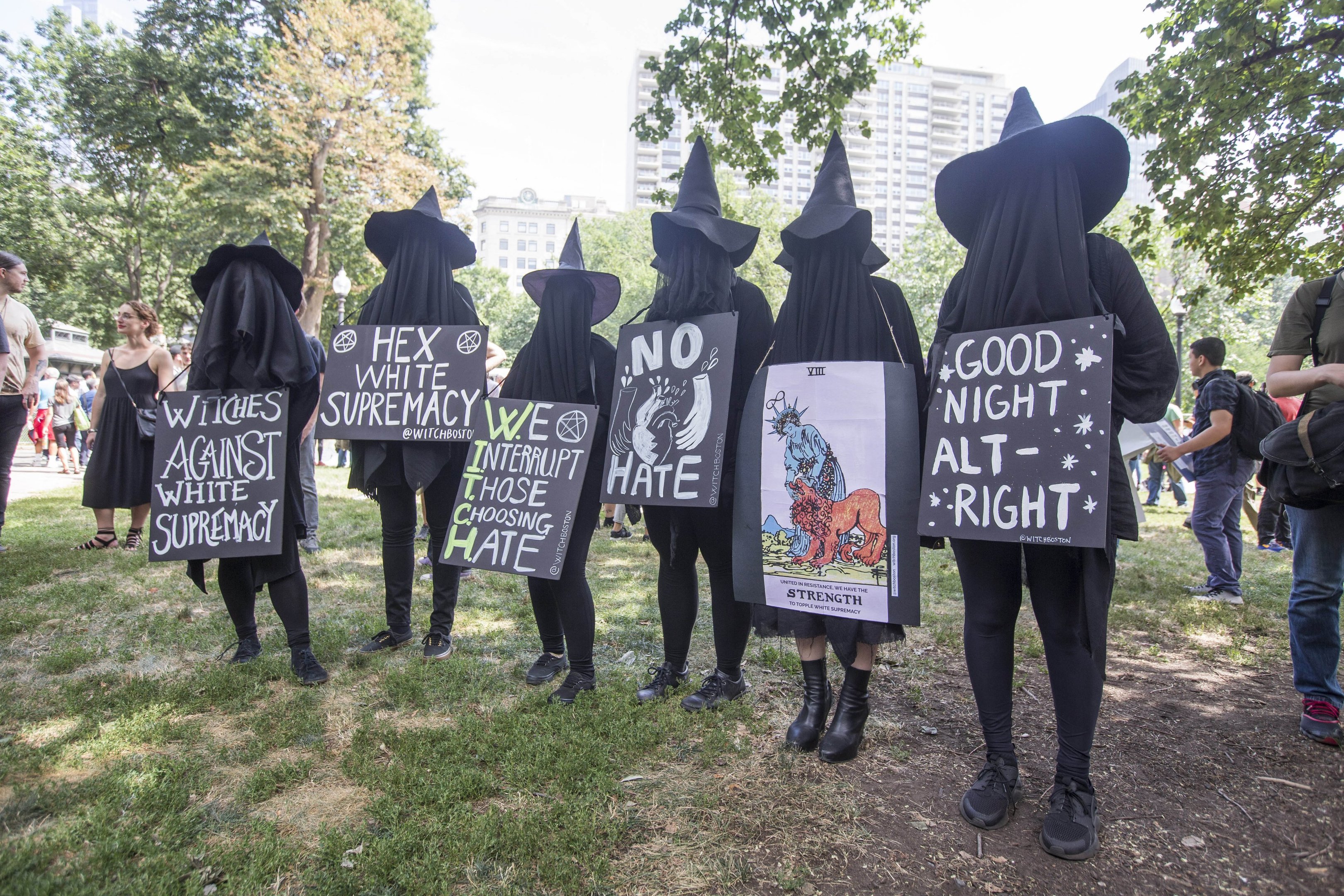 Pessoas vestidas de bruxa em Boston com sinais contra o ódio, supremacistas brancos e a "direita alternativa"