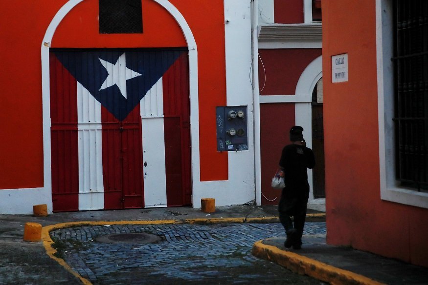 A man walks down a street in the Hurricane Maria affected area of Old San Juan