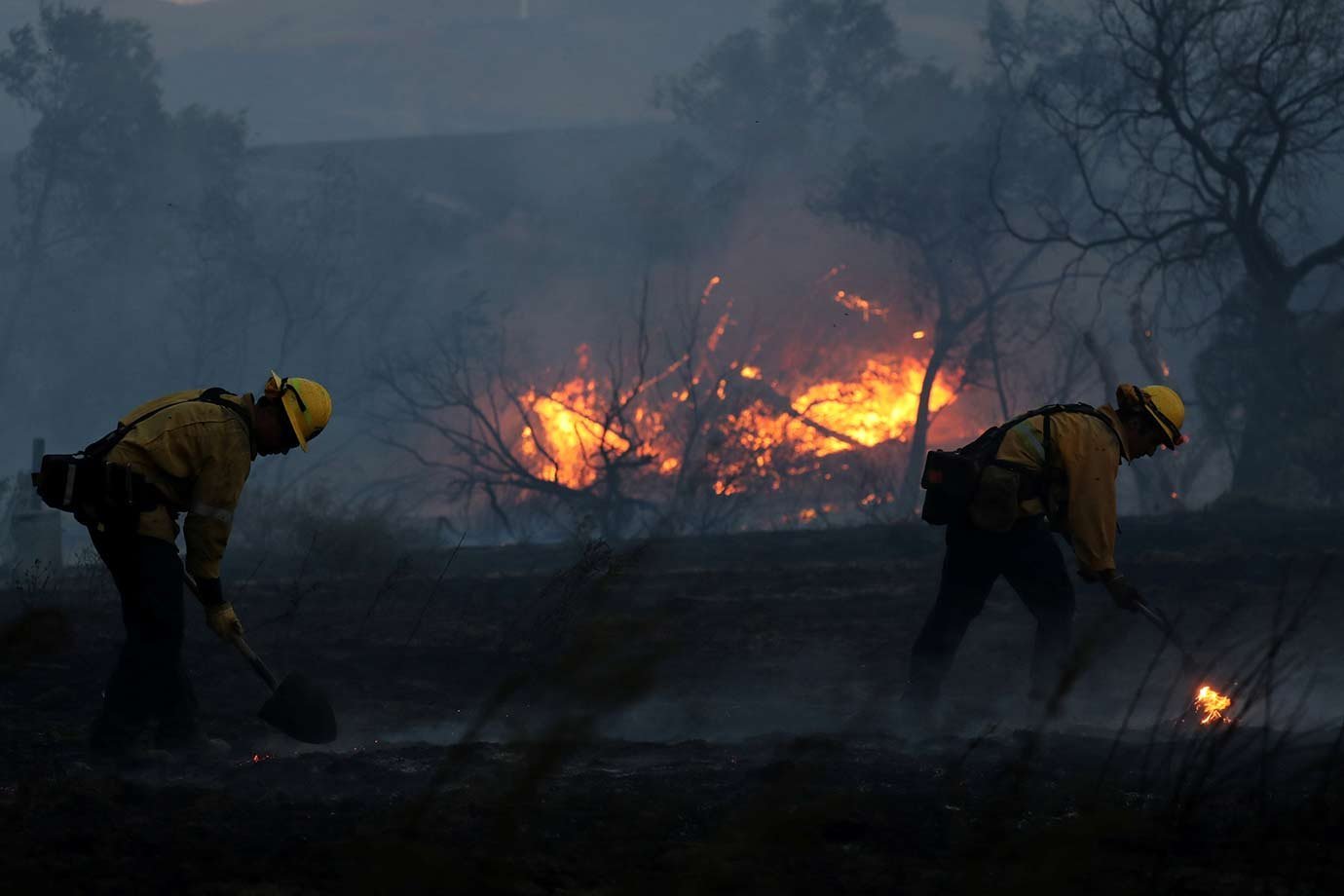 Bombeiros combatem focos de incêndio em rodovia em Orange, Califórnia. 