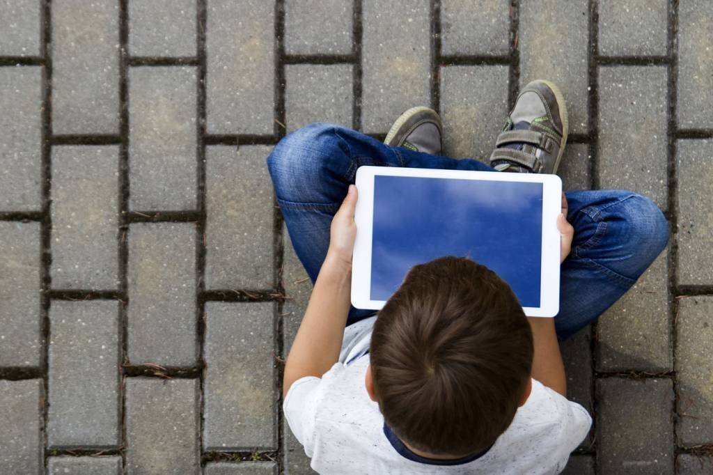 Menino usa tablet em escola