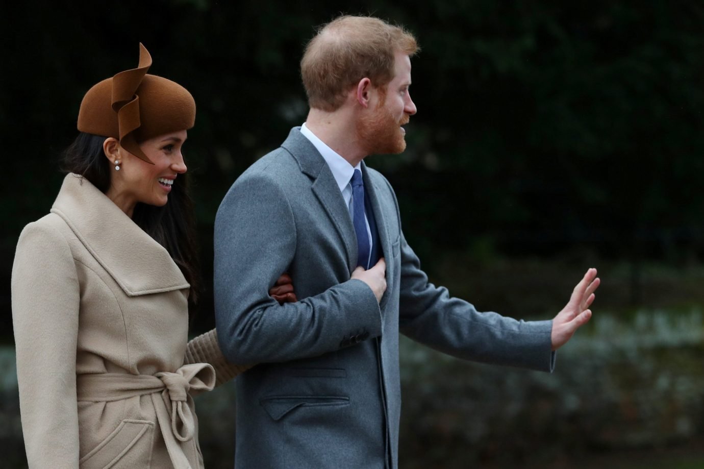 Meghan Markle e príncipe Harry acenam para o público após a celebração de Natal da família real britânica