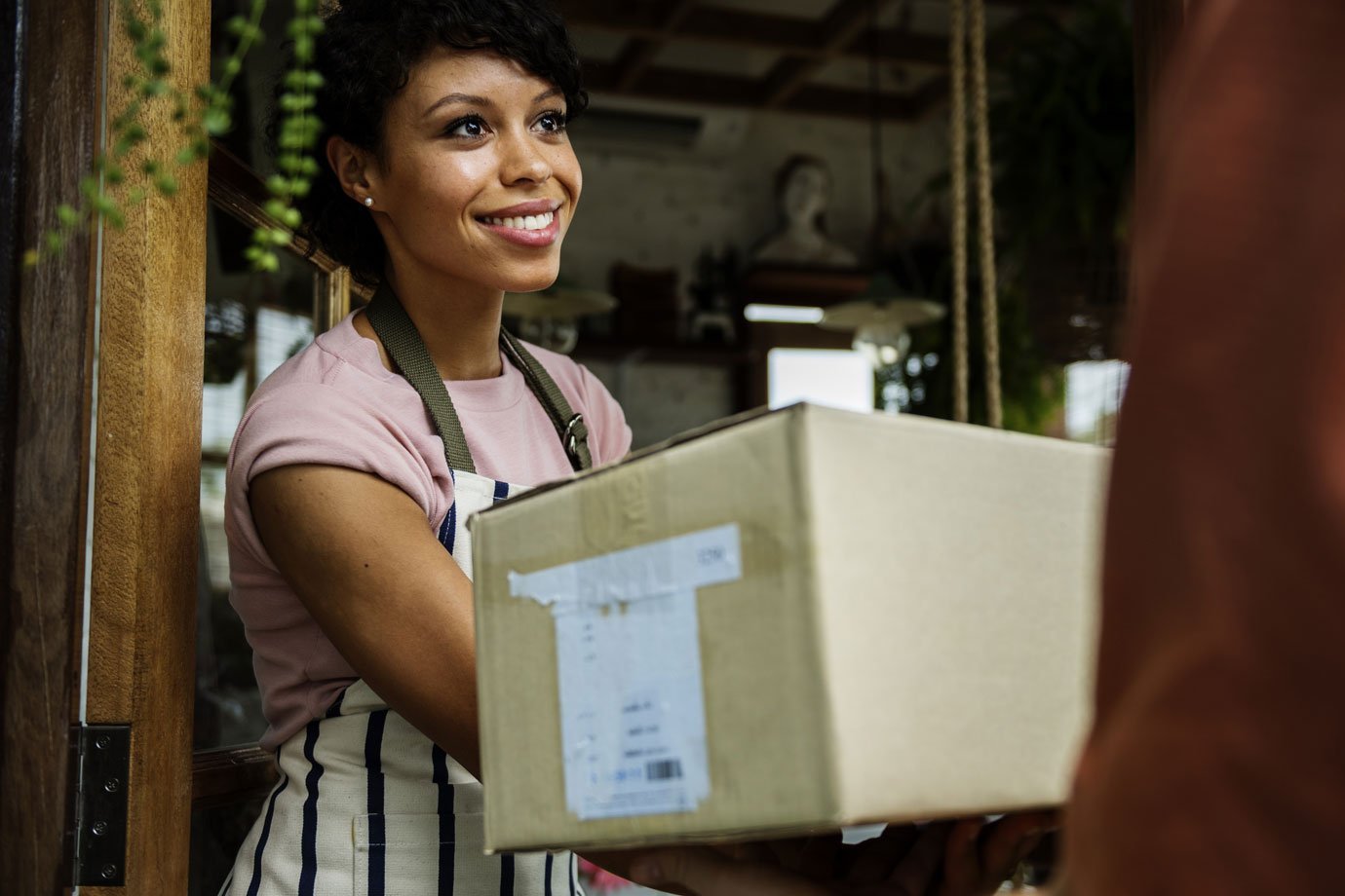 Mulher recebe caixa de entregador de delivery