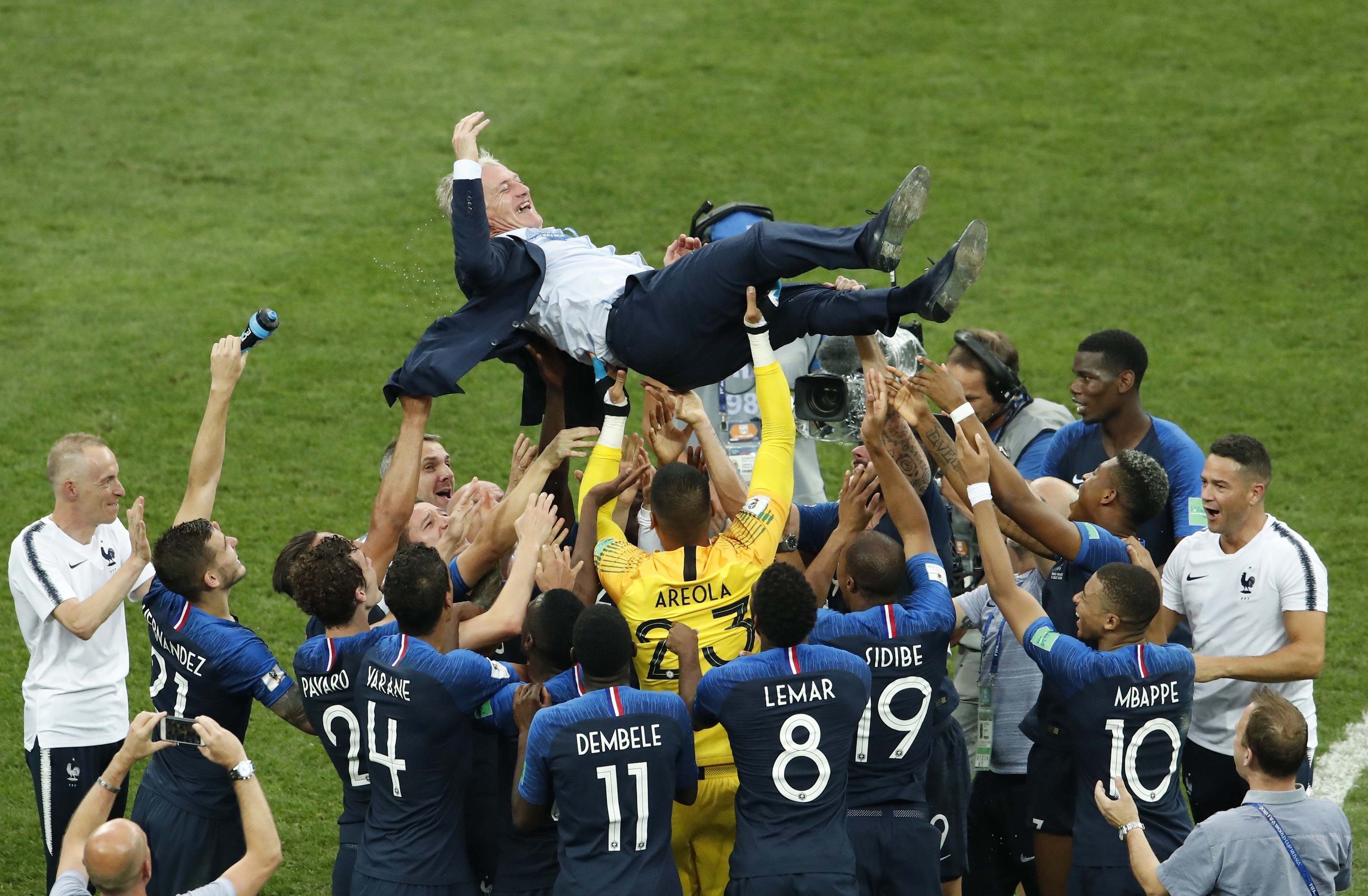 Jogadores francese celebram vitória erguendo o técnico Didier Deschamps