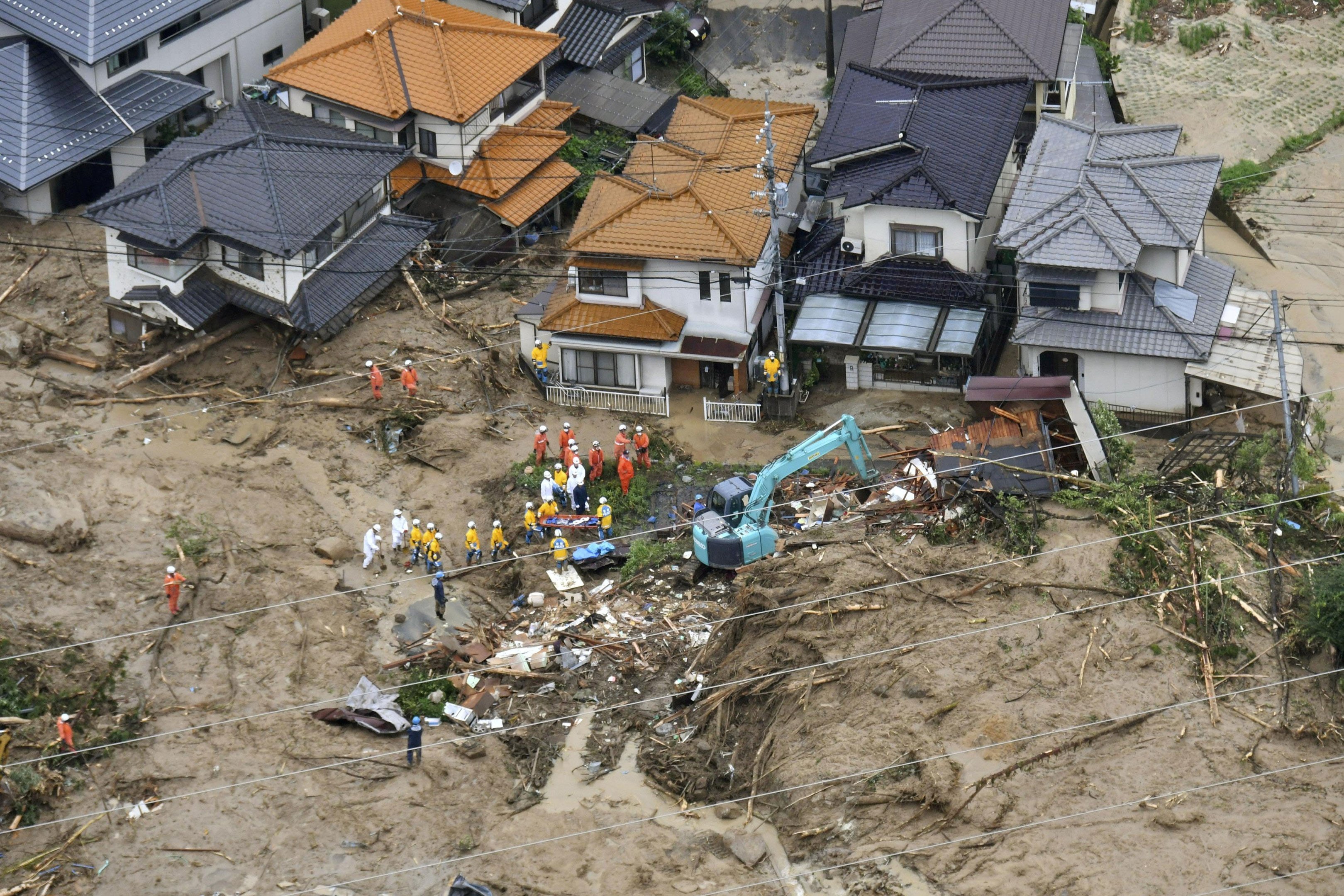 Trabalhadores de resgate em casas danificadas em Hiroshima, no Japão, após fortes chuvas