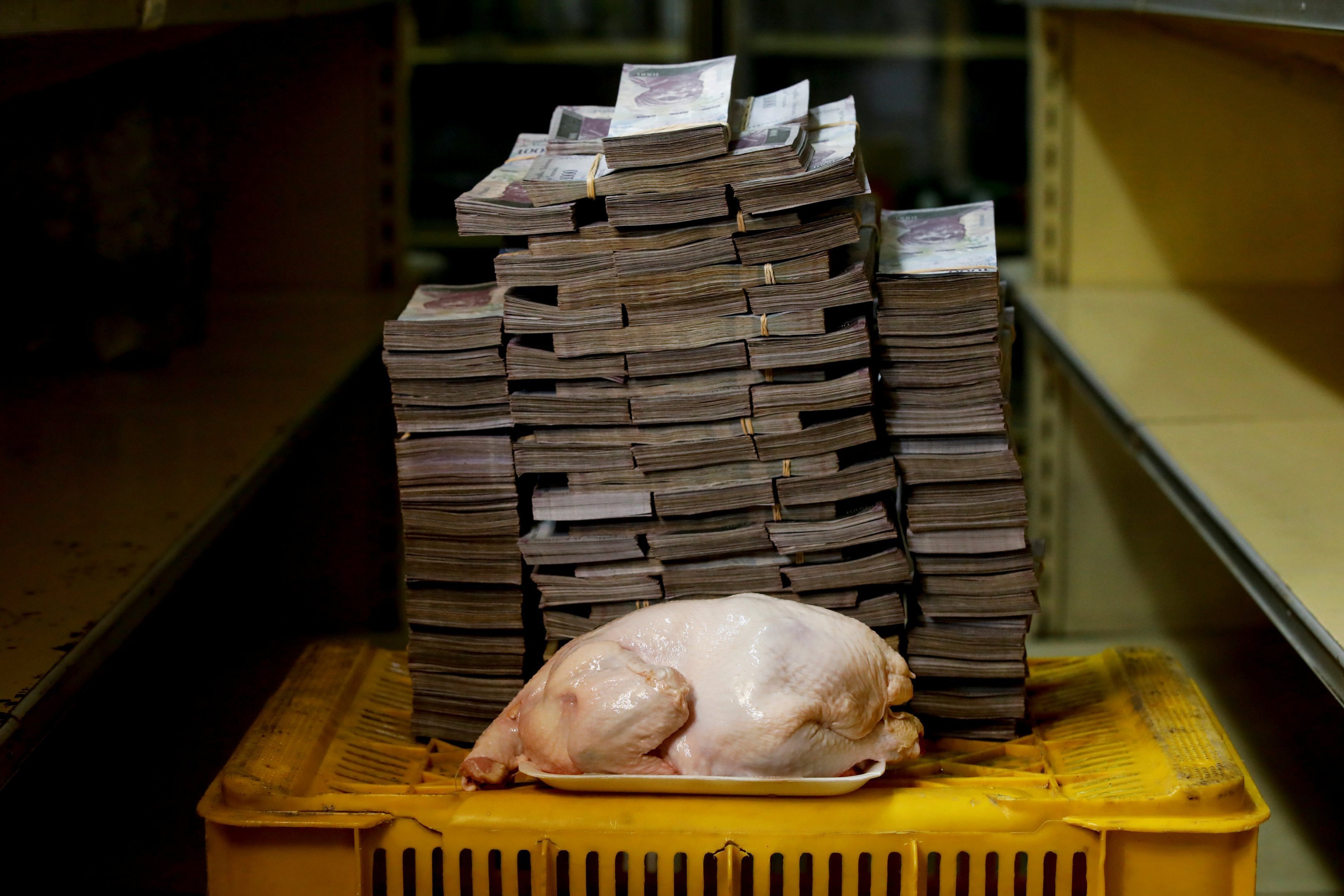 Um frango de 2,4 quilos e pilhas de bolívares em Caracas, na Venezuela