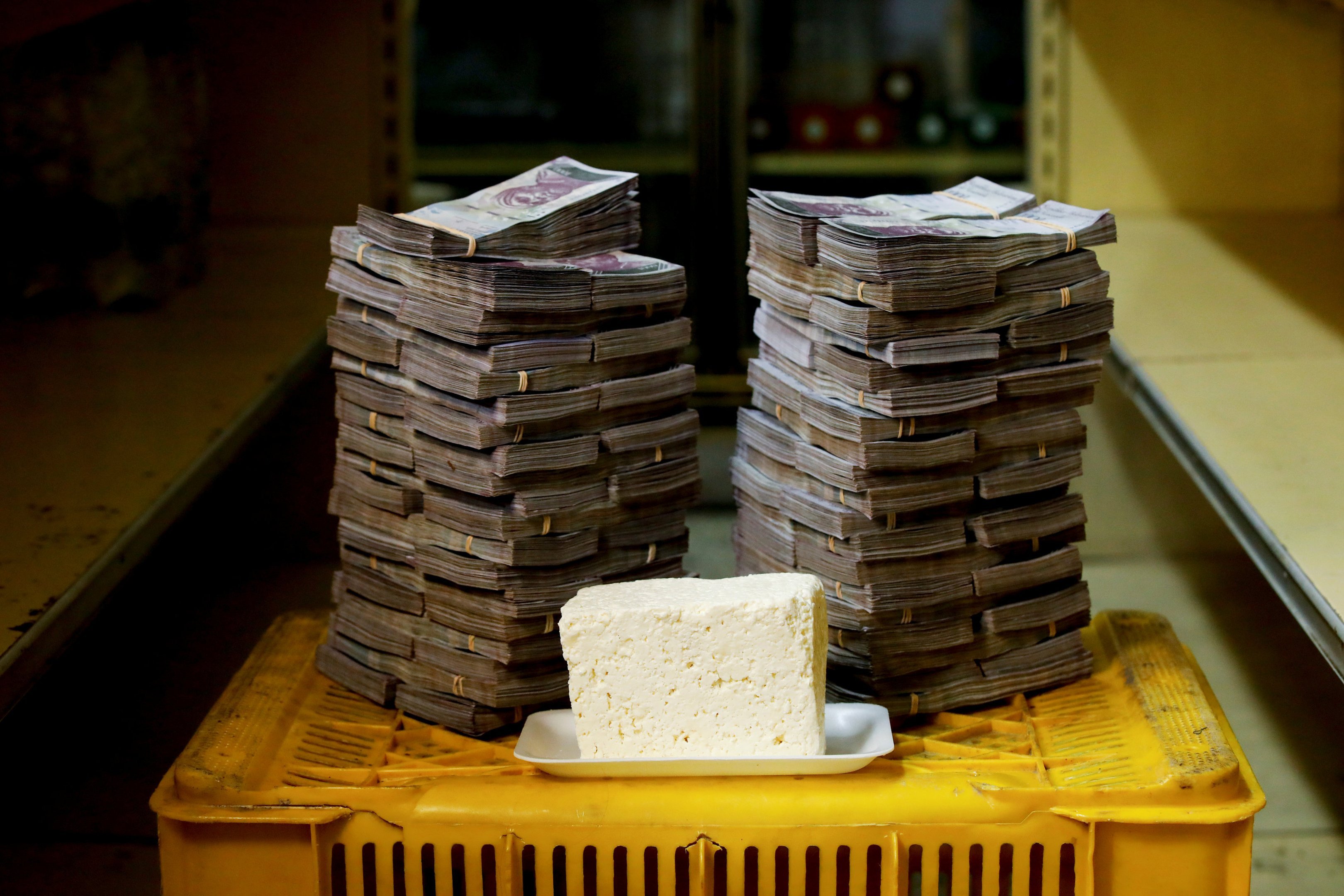 Um quilo de queijo e pilhas de bolívares em Caracas, na Venezuela