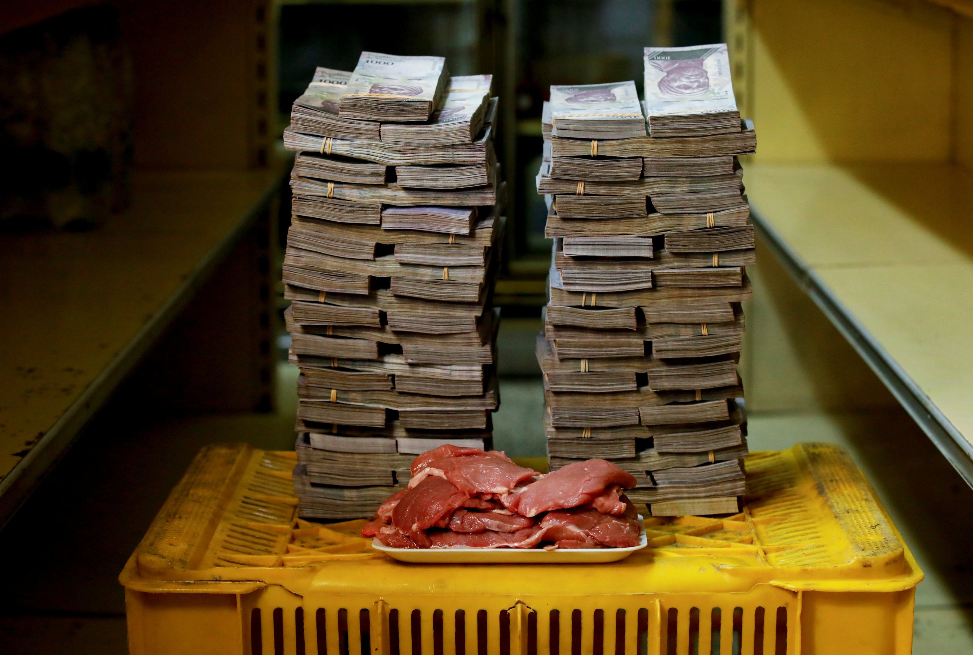 Quilo de carne e pilhas de bolívares em Caracas, na Venezuela