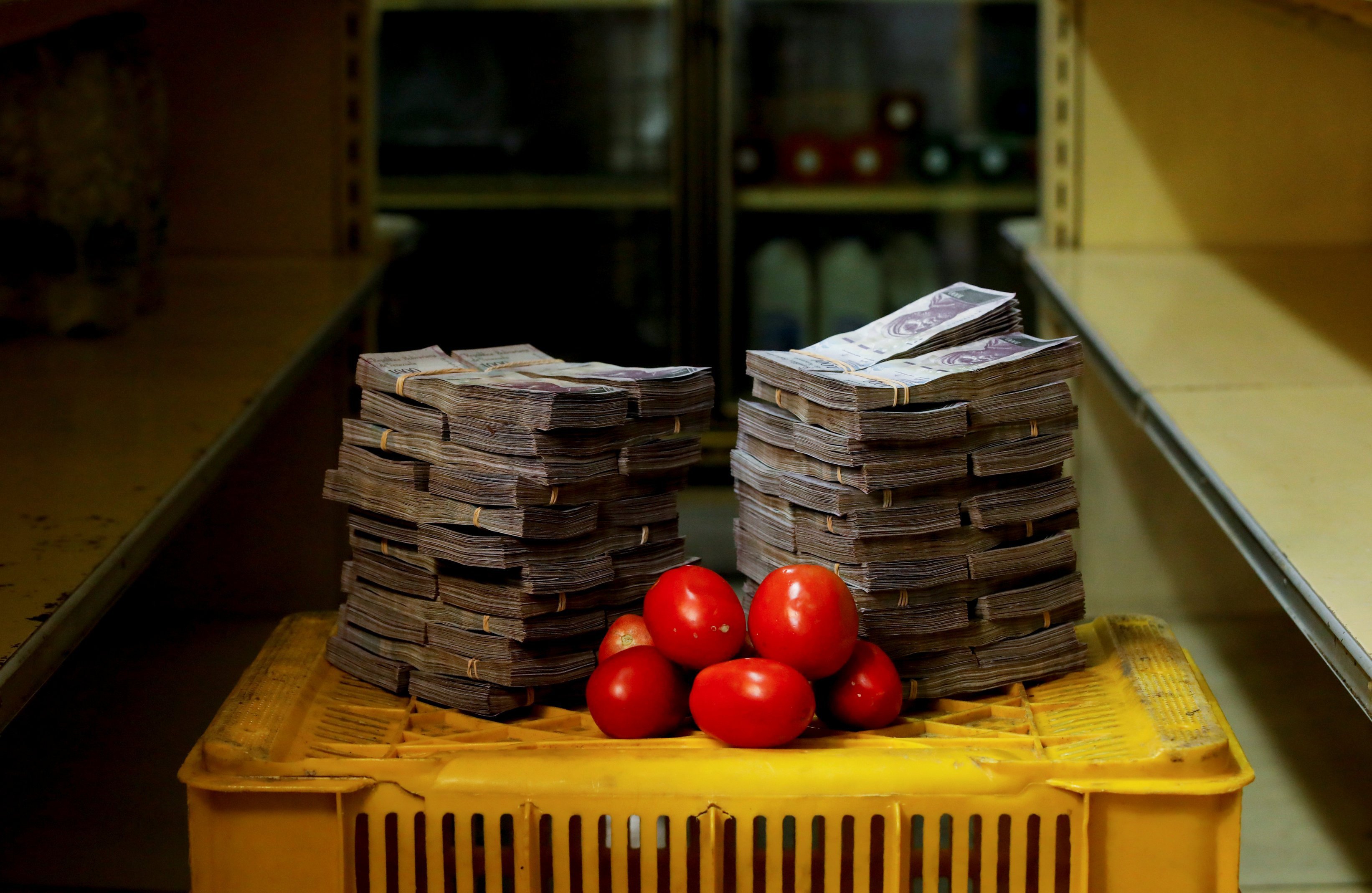 Um quilo de tomates e pilhas de bolívares em Caracas, na Venezuela