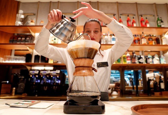 FILE PHOTO: An employee prepares a coffee inside the new Starbucks Reserve Roastery flagship in downtown Milan