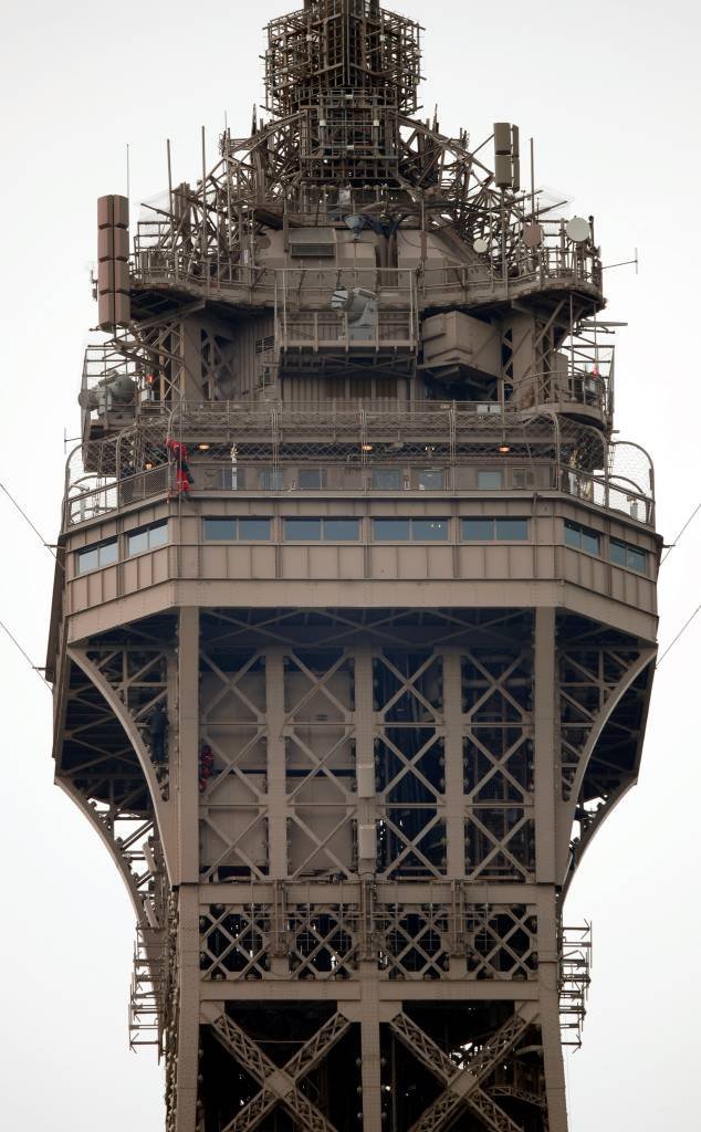 Homem escala a Torre Eiffel, em Paris