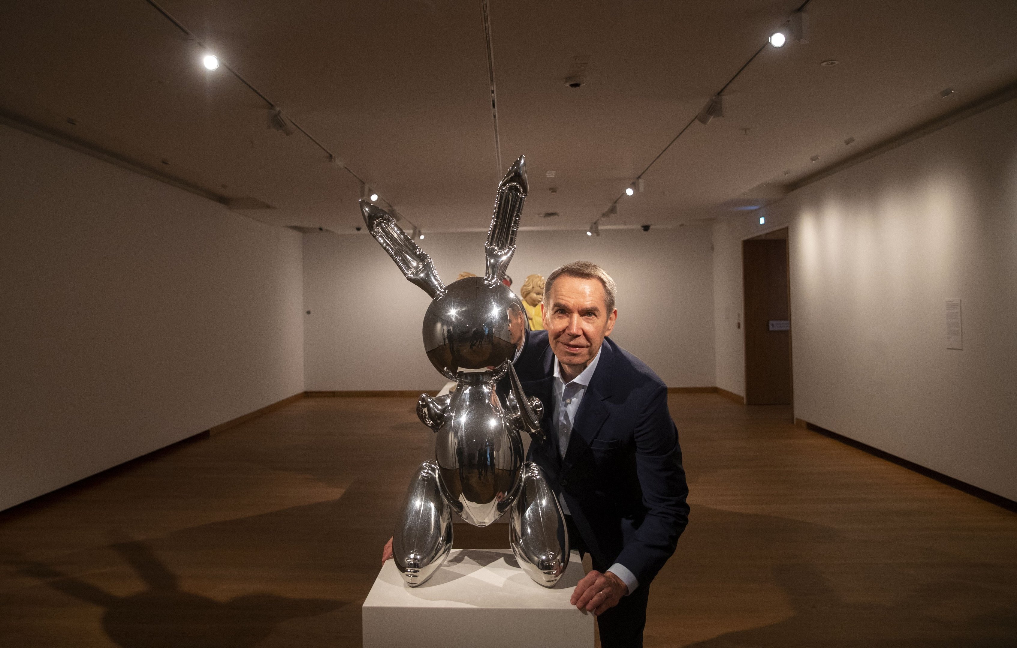 Jeff Koons ao lado de sua escultura Rabbit, em Oxford