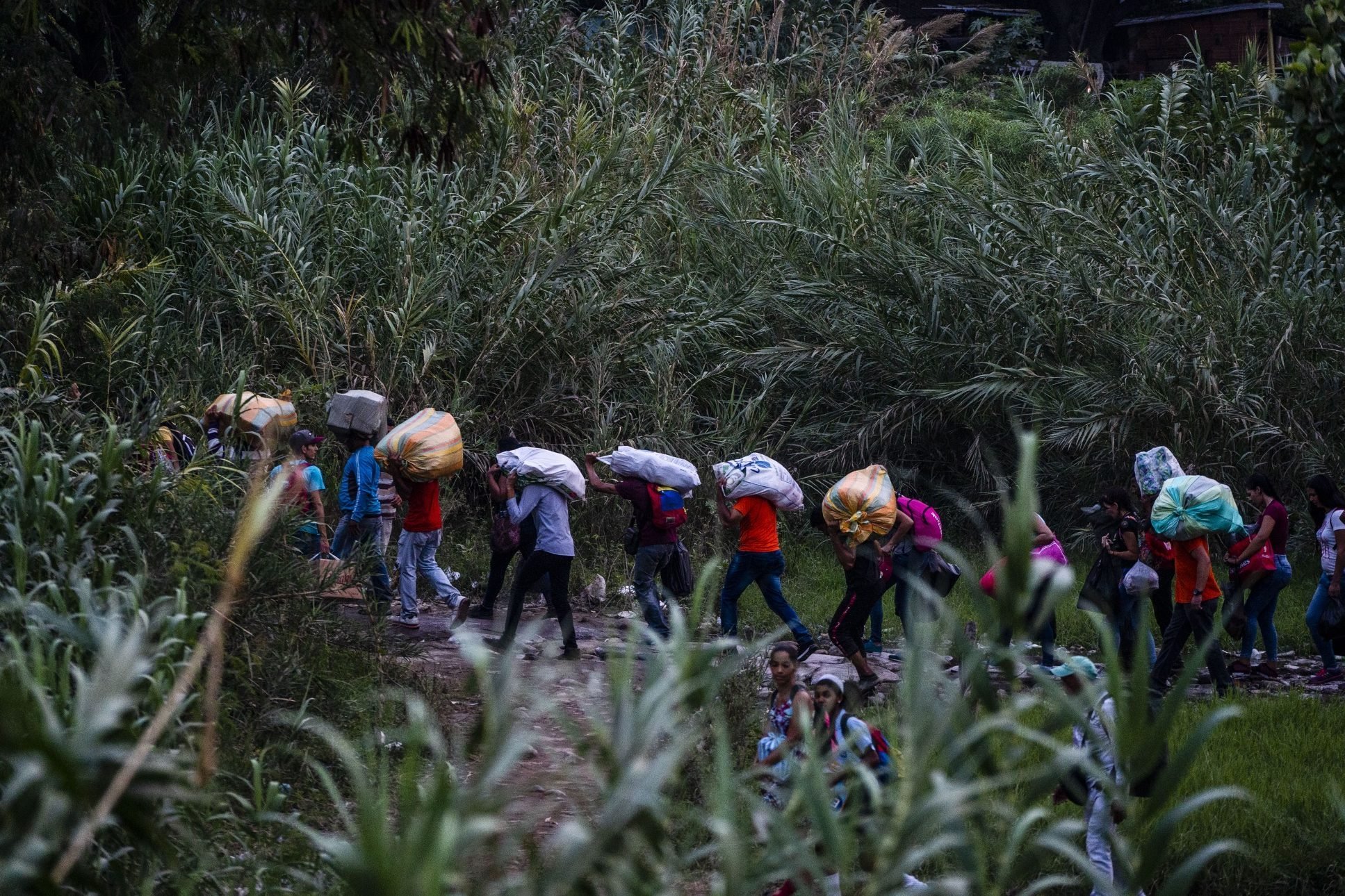 Venezuelanos carregam pertences perto da fronteira da Venezuela com a Colômbia. Março de 2019. Foto: Federico Rios/Bloomberg