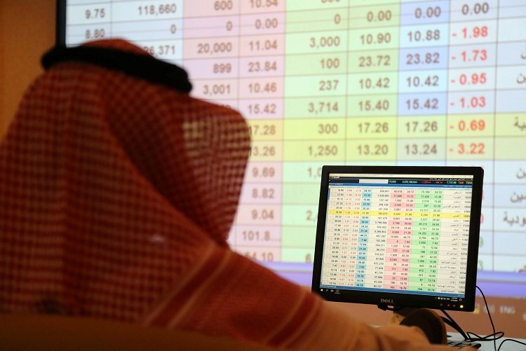 A saudi man looks to the computer showing stock prices at ANB Bank, in Riyadh