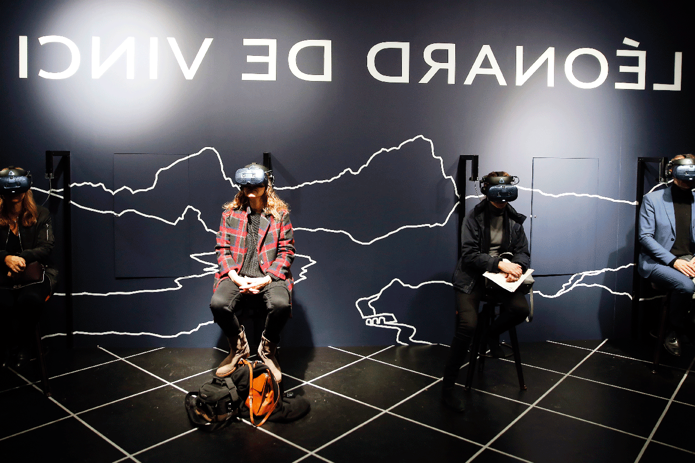 Visitantes usam realidade virtual durante a exposição de Da Vinci no Louvre