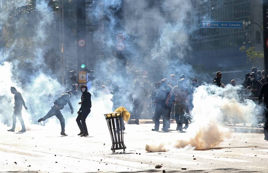 Manifestantes são vistos em meio à fumaça de gás lacrimogêneo durante protesto contra o presidente Jair Bolsonaro, na Avenida Paulista, em São Paulo, 31 de maio de 2020.