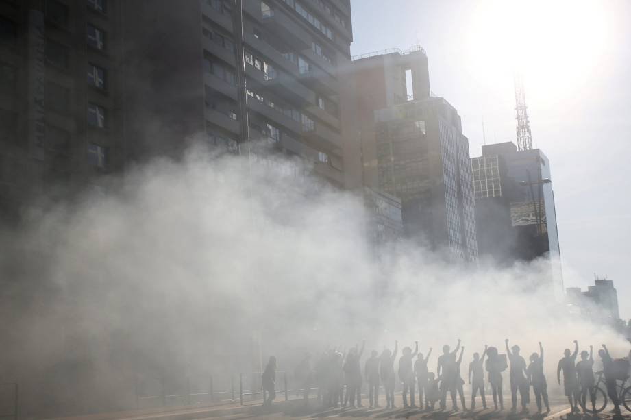 Manifestantes são vistos entre gás lacrimogêneo durante um protesto contra o presidente brasileiro Jair Bolsonaro na Avenida Paulista, em São Paulo, Brasil, 31 de maio de 2020.