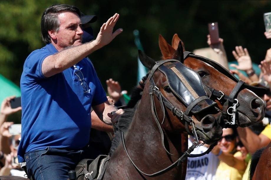 O presidente do Brasil, Jair Bolsonaro, monta um cavalo durante uma reunião com apoiadores protestando a seu favor, em meio ao surto de doença por coronavírus (COVID-19), em Brasília, Brasil, 31 de maio de 2020.