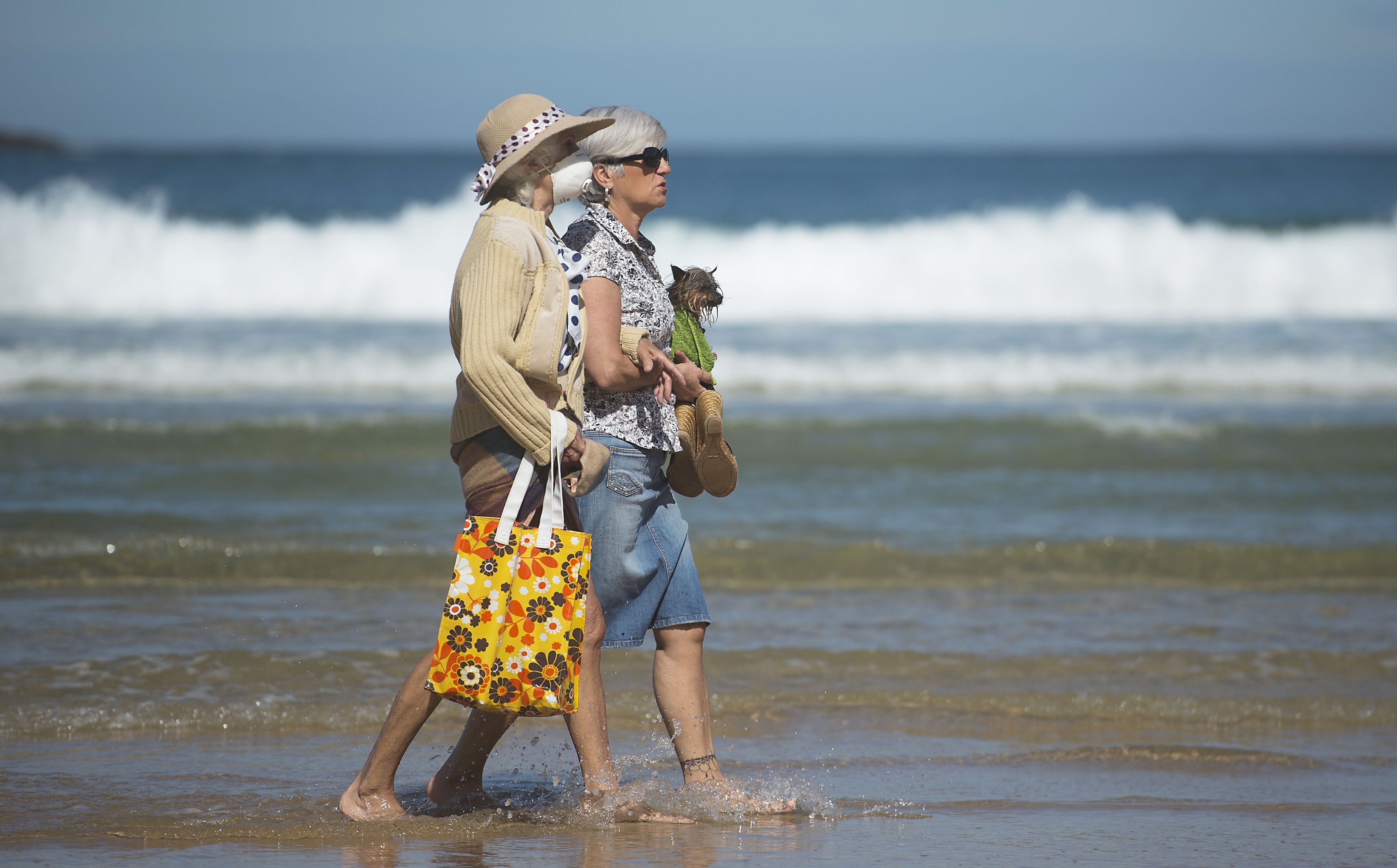 Mulheres caminham na praia de San Sebastian, na Espanha, durante pausa da quarentena