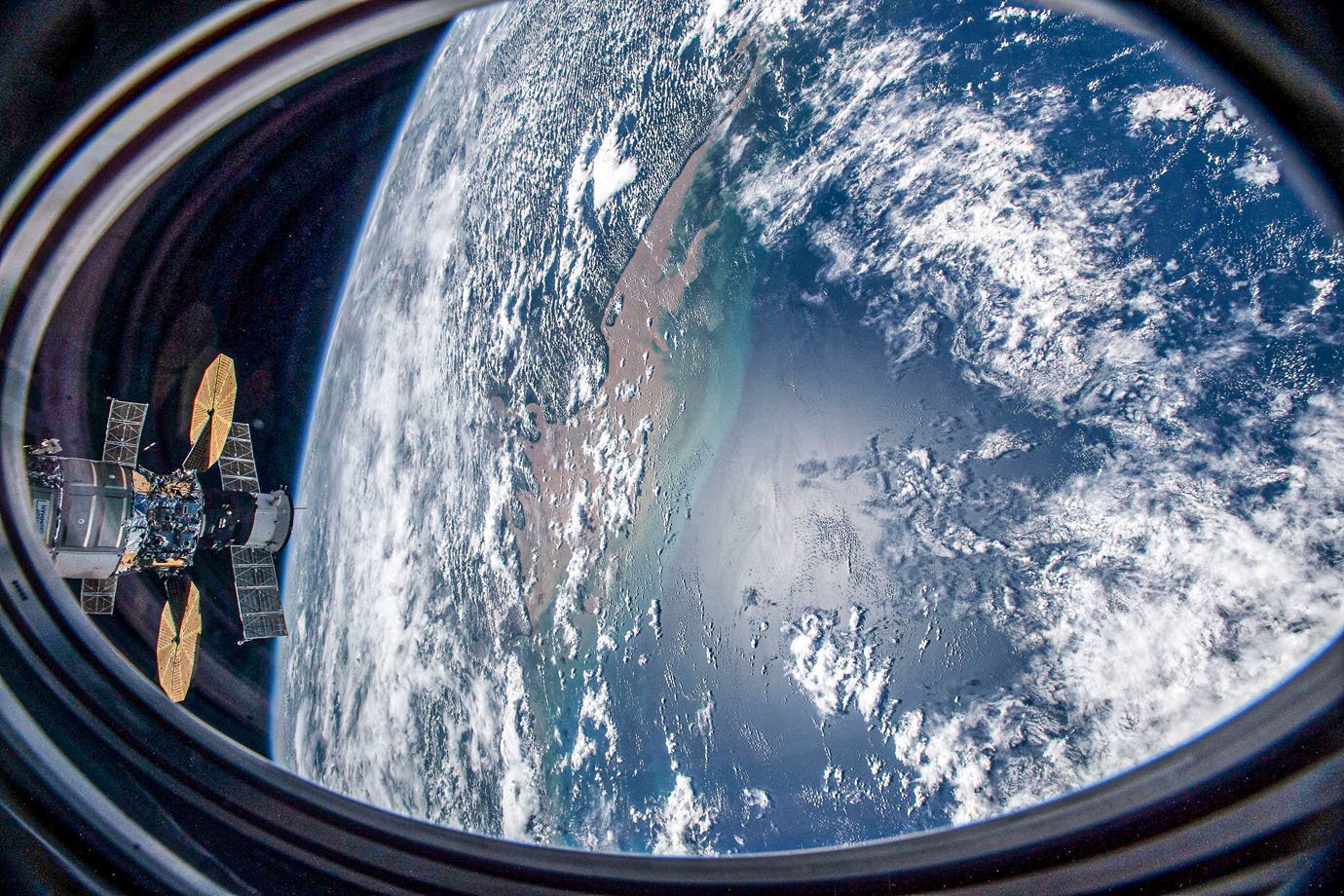 (27 de novembro de 2020) — Esta foto foi tirada de uma janela do veículo SpaceX Crew Dragon enquanto a Estação Espacial Internacional orbitava sobre o Oceano Atlântico próximo à costa do Brasil perto da foz do Rio Amazonas. Duas outras espaçonaves, incluindo a nave de carga Cygnus com seus dois painéis solares em forma de címbalo proeminentes e, atrás dele, a tripulação russa Soyuz MS-17 com seus painéis solares retangulares, também são retratados atracados no laboratório orbital