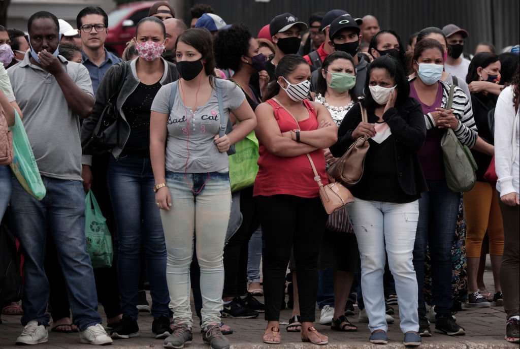 Pessoas usando máscaras andam pelas movimentadas ruas comerciais do centro de São Paulo em 10 de dezembro de 2020.