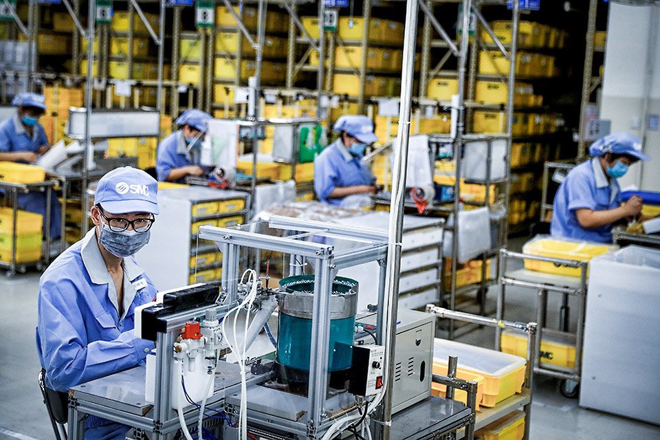 Funcionários usando máscaras faciais trabalham em uma fábrica da fabricante de componentes SMC durante um tour organizado pelo governo em suas instalações após o surto da doença coronavírus (COVID-19), em Pequim, China, em 13 de maio de 2020. REUTERS / Thomas Peter