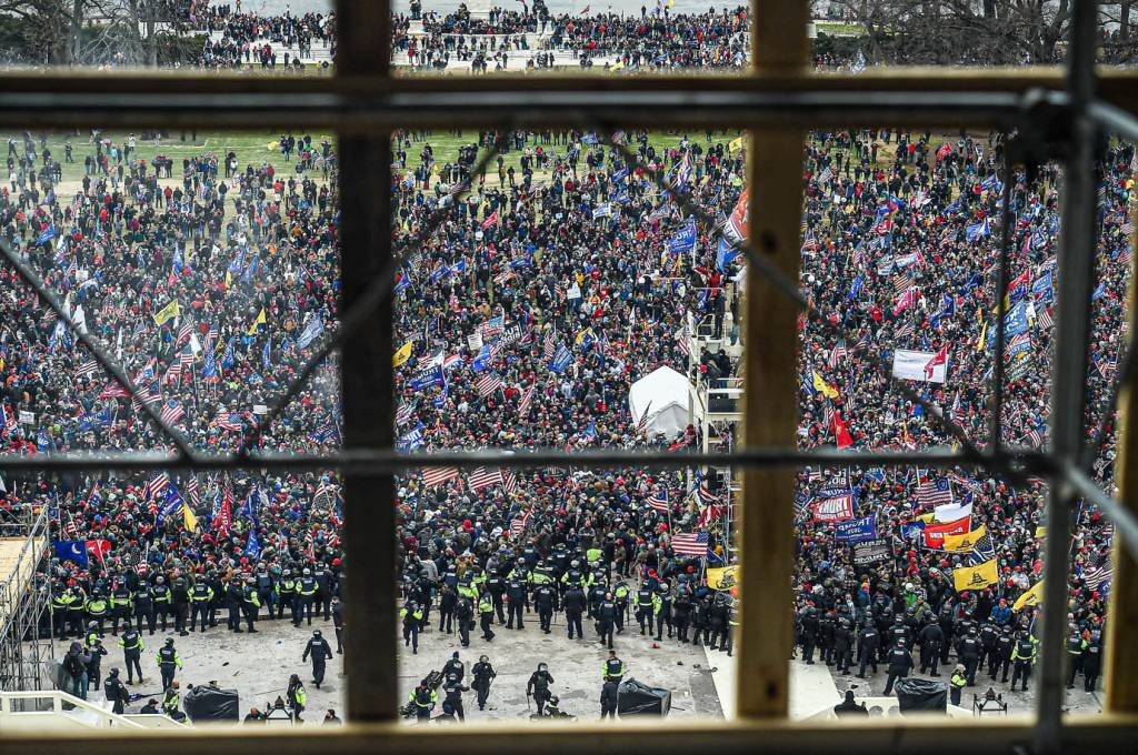 A polícia segura os apoiadores do presidente dos EUA, Donald Trump, enquanto eles se reúnem em frente à Rotunda do Capitólio dos EUA em 6 de janeiro de 2021, em Washington, DC. - Os manifestantes violaram a segurança e entraram no Capitólio enquanto o Congresso debatia a Certificação de Voto Eleitoral da eleição presidencial de 2020. (Foto de Olivier DOULIERY / AFP) (Foto de OLIVIER DOULIERY / AFP via Getty Images)