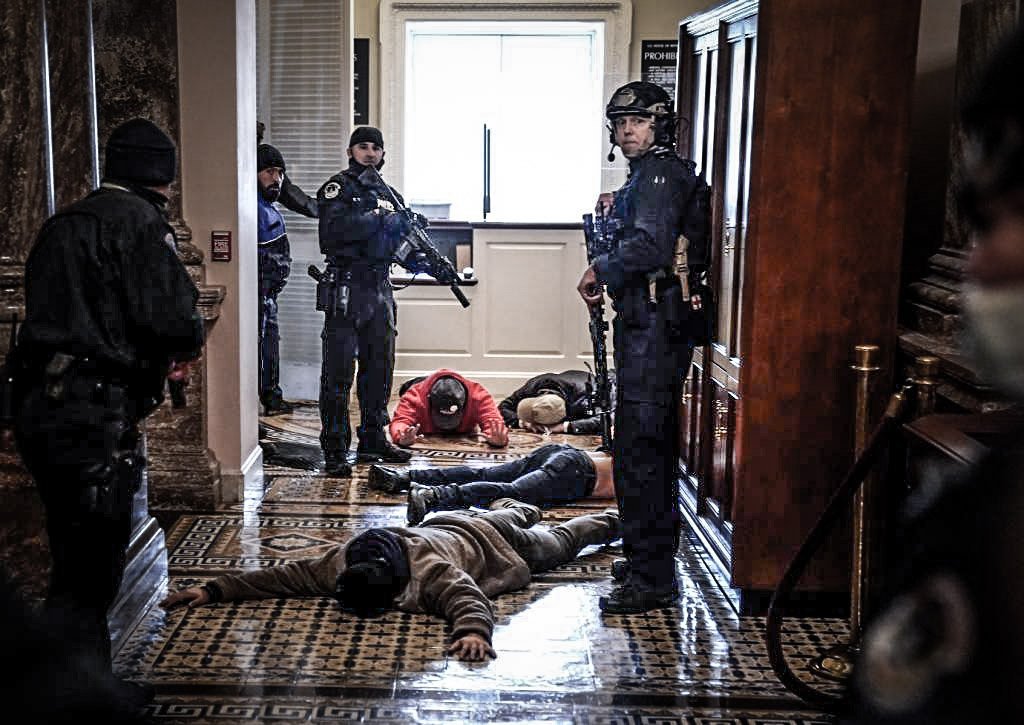 A polícia do Capitólio detém manifestantes do lado de fora da Câmara da Câmara durante uma sessão conjunta do Congresso em 6 de janeiro de 2021 em Washington, DC. O Congresso realizou uma sessão conjunta hoje para ratificar a vitória do Colégio Eleitoral 306-232 do presidente eleito Joe Biden sobre o presidente Donald Trump. Um grupo de senadores republicanos disse que rejeitaria os votos do Colégio Eleitoral de vários estados, a menos que o Congresso indicasse uma comissão para auditar os resultados das eleições