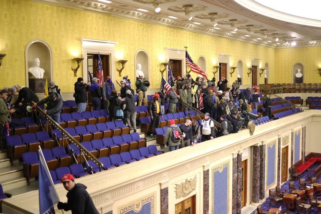 Os manifestantes entram na Câmara do Senado em 06 de janeiro de 2021 em Washington, DC. O Congresso realizou uma sessão conjunta hoje para ratificar a vitória do Colégio Eleitoral 306-232 do presidente eleito Joe Biden sobre o presidente Donald Trump. Manifestantes pró-Trump entraram no edifício do Capitólio dos EUA após manifestações em massa na capital do país