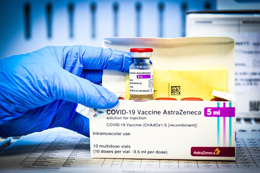 Profissional de saúde mostra caixas e frasco da vacina contra Covid-19 da AstraZeneca