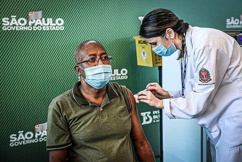 SÃO PAULO, BRASIL - 17 DE JANEIRO: A enfermeira Wilson Paes de Padua (57) recebe a vacina CoronaVac da enfermeira do Controle de Doenças e Mestre em Saúde Pública da Santa Casa de São Paulo, Jessica Pires de Camargo, 30 anos no Hospital das Clínicas da Universidade de São Paulo (USP) em 17 de janeiro de 2021 em São Paulo, Brasil. A vacina CoronaVac foi desenvolvida pelo laboratório chinês Sinovac em parceria com o Instituto Butantan. A Agência Nacional de Vigilância Sanitária (Anvisa) autorizou hoje o uso emergencial do CoronaVac e do AstraZeneca (desenvolvido pela Universidade de Oxford em parceria com a Fundação Oswaldo Cruz (Fiocruz) vacinas contra Covid-19. (Foto Rodrigo Paiva / Getty Images )