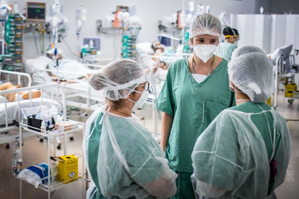 Trabalhadores de saúde tratam pacientes dentro de uma unidade de terapia intensiva (UTI) Covid-19 em um hospital de campanha na favela Heliópolis de São Paulo, Brasil, na sexta-feira, 19 de março de 2021.
