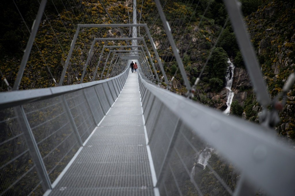 Pessoas a atravessar pela primeira vez a Ponte de Arouca 516, a maior ponte pedonal suspensa do mundo, em Arouca, norte de Portugal, a 29 de abril de 2021