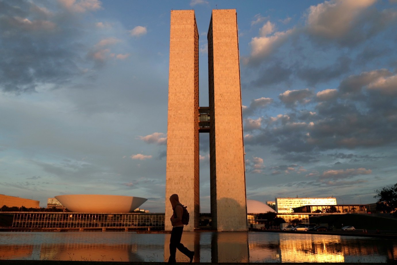 Homem caminha perto do prédio do Congresso Nacional em Brasília