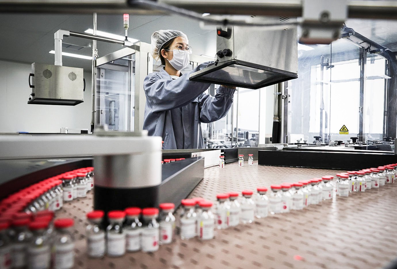 Funcionário trabalha na linha de produção da vacina de dose única contra a Covid-19 da CanSino em Tianjin, China.