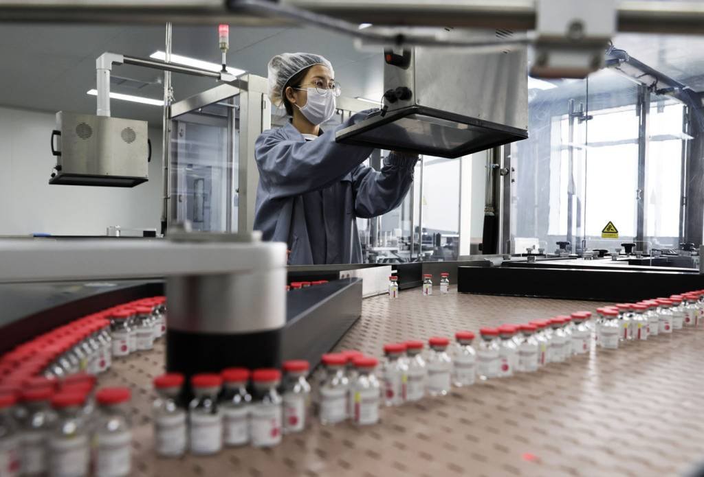 Funcionário trabalha na linha de produção da vacina de dose única contra a Covid-19 da CanSino em Tianjin, China.