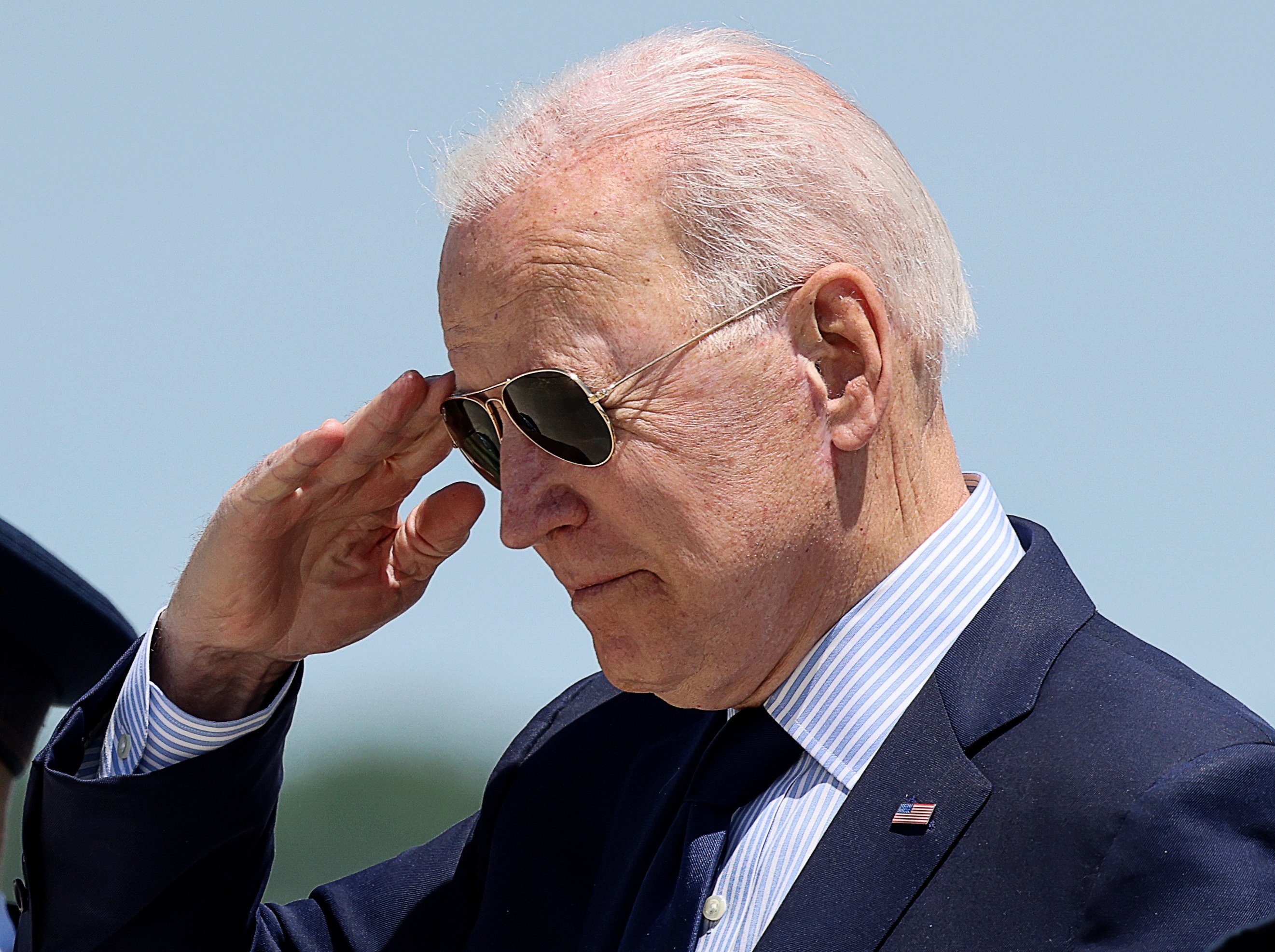 Joe Biden faz saudação com a mão e usa óculos escuros