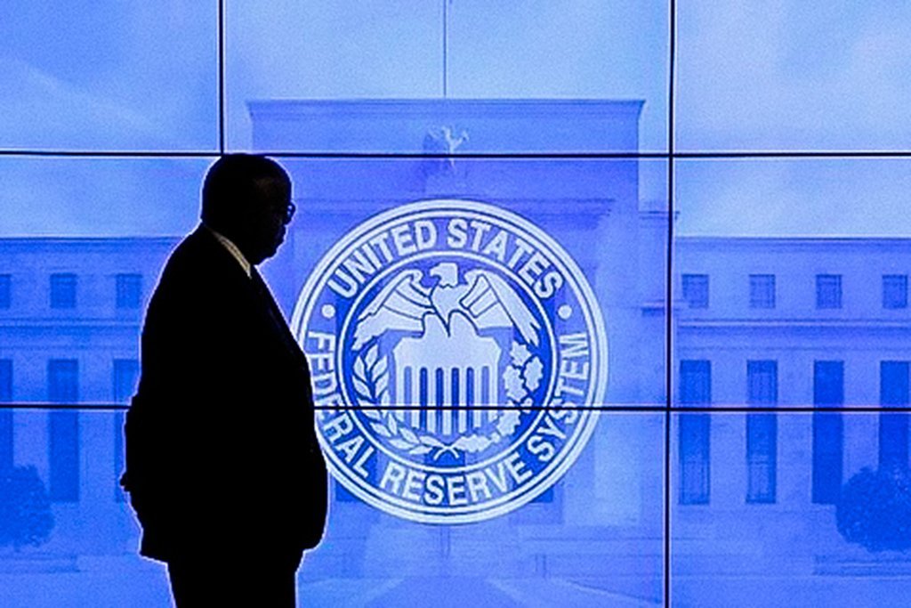 Homem passa por logo do Federal Reserve em Washington, Estados Unidos